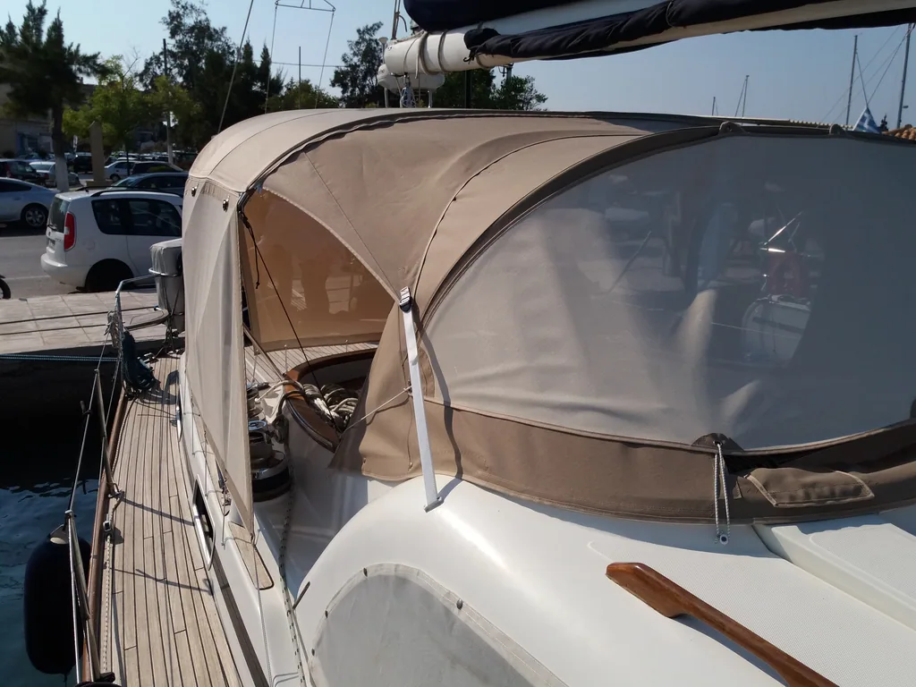 Tan sprayhood and cockpit enclosure fitted on a yacht in a marina