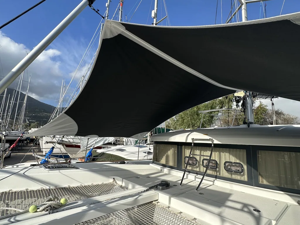 Black shade sail tensioned over the foredeck of a yacht