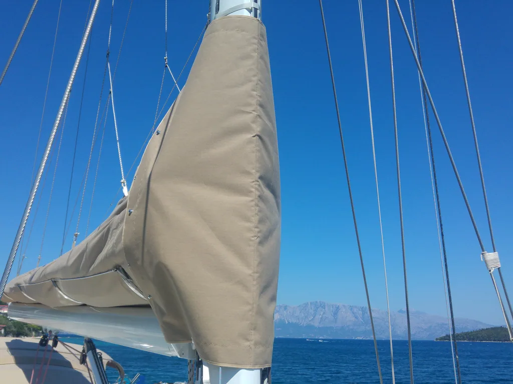 Cream lazy bag closed along the boom, open sea beyond