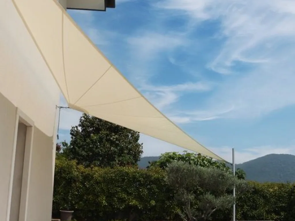 Cream sail shading a terrace, hills beyond