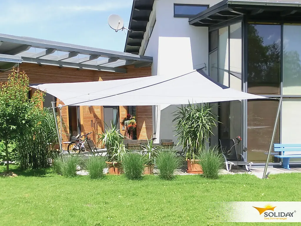 Light grey Soliday sail shading a terrace in front of a modern timber and white house
