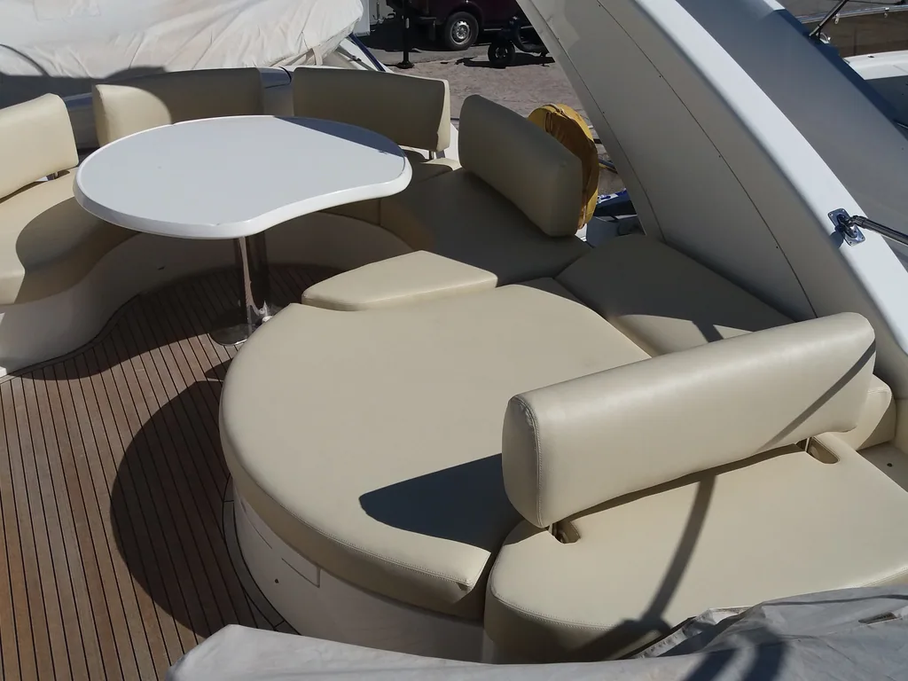 Cream cockpit settee wrapped around a table on a teak deck