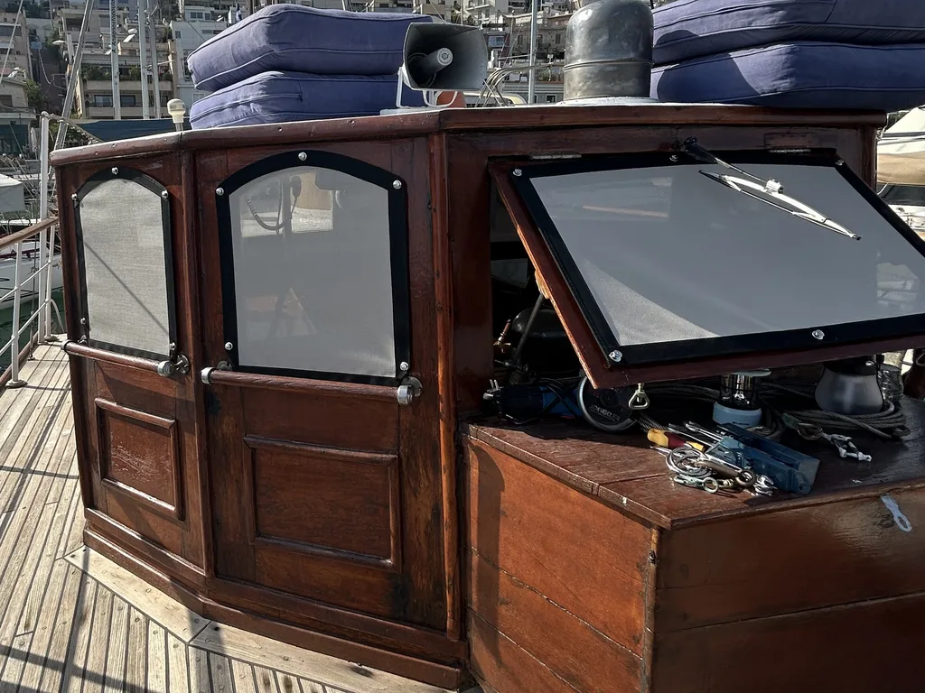 Mesh screen covers fitted over the wheelhouse windows of a classic wooden yacht