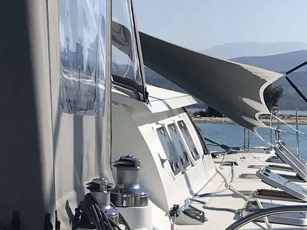 Cockpit enclosure with clear panels and a shade sail over the side deck of a yacht
