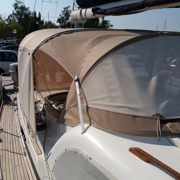 Tan sprayhood and cockpit enclosure fitted on a yacht in a marina