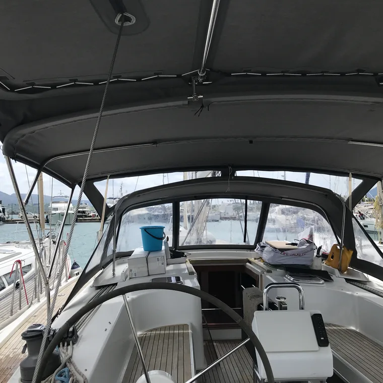 Dark bimini stretched over the cockpit and wheel in a marina