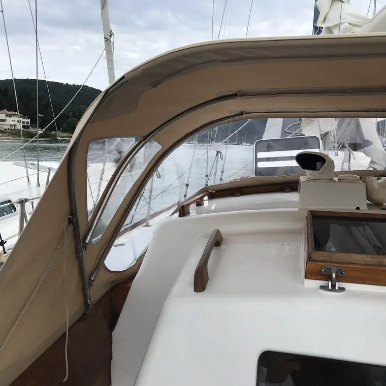 Curved tan sprayhood framing the companionway of a yacht