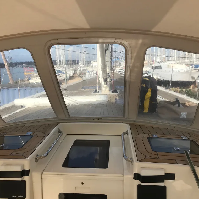 Tan sprayhood with clear windows, looking aft over the marina