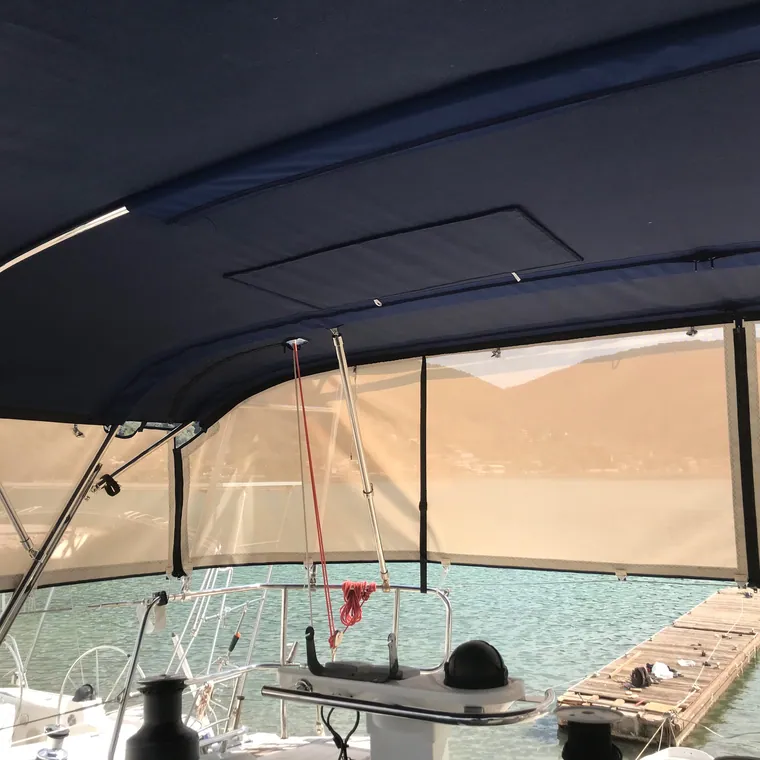 Navy bimini shading a cockpit, the beach and shallow water beyond