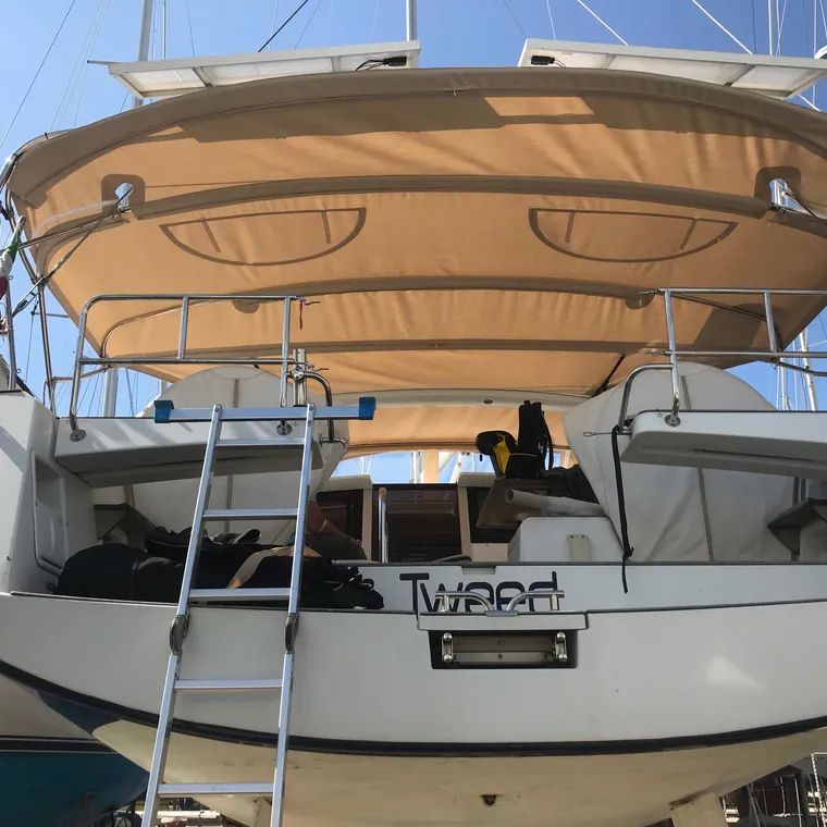 Cream bimini over the cockpit of a motor yacht at her berth