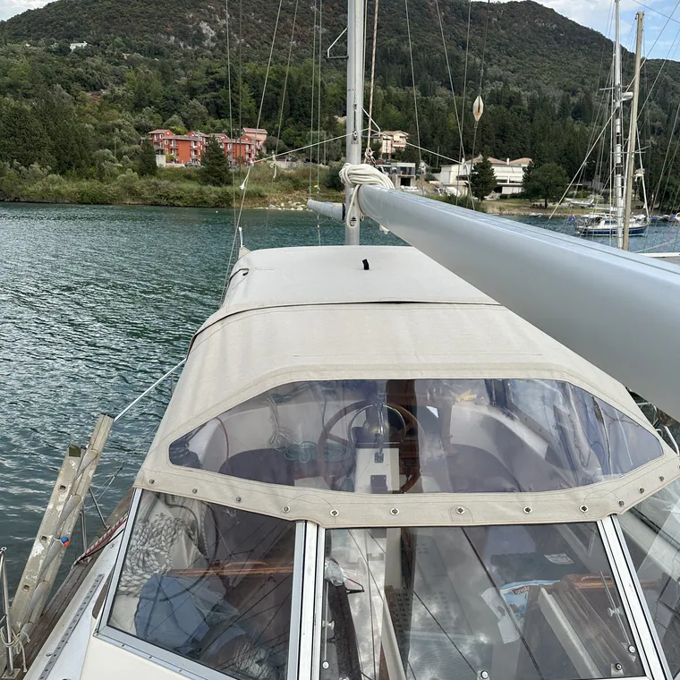 White sprayhood with clear windows on a yacht moored in a green bay