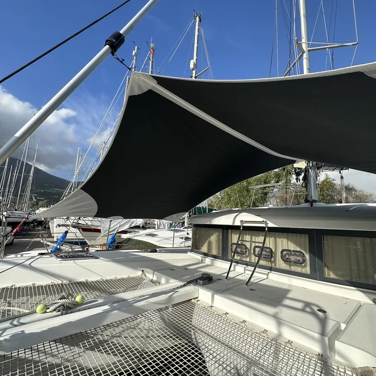Black shade sail tensioned over the foredeck of a yacht