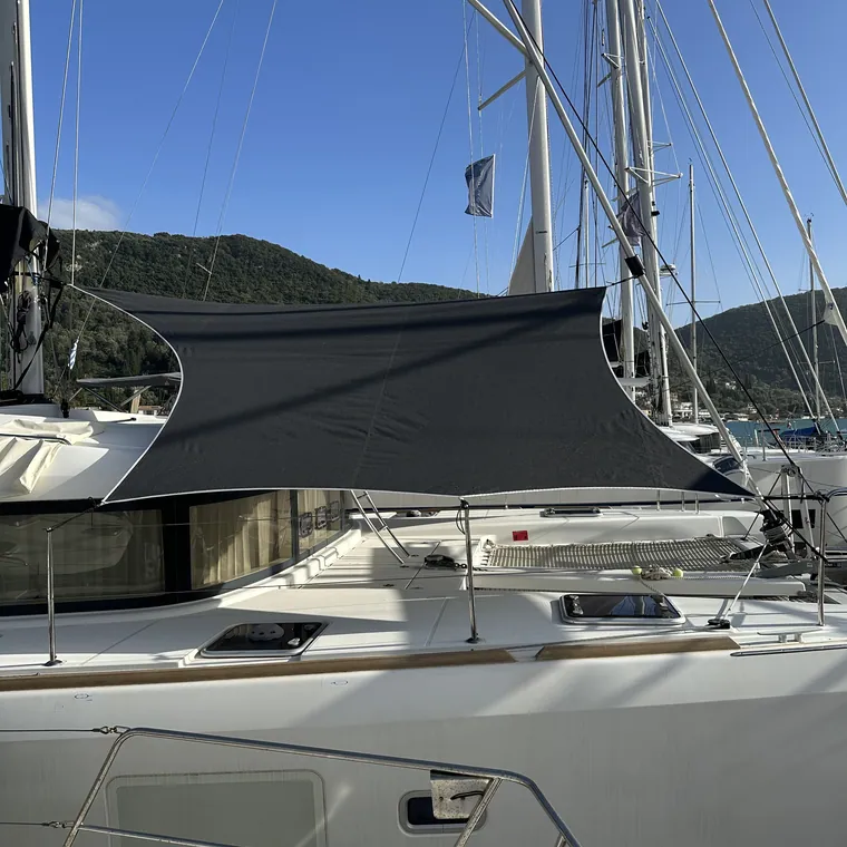 Dark awning stretched over the cockpit, hills behind the bay