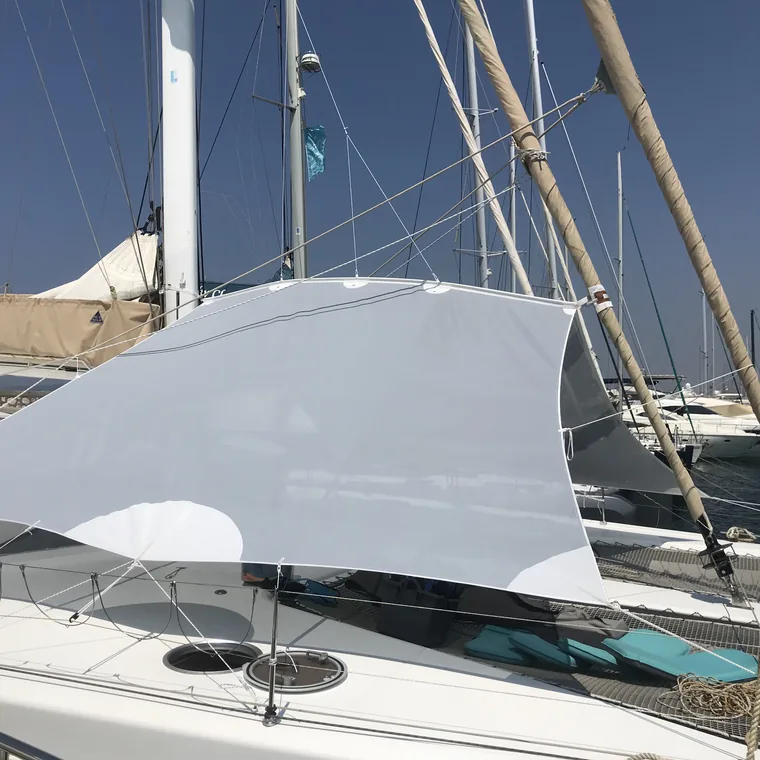 White shade sail over the cockpit of a catamaran