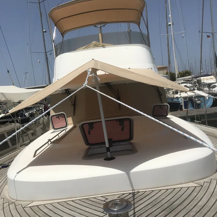 Tan awning over the foredeck cushions of a motor yacht