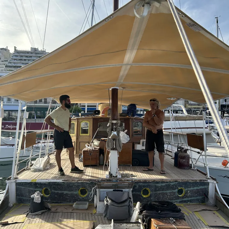 Tan sun awning shading the deck while the crew work below it