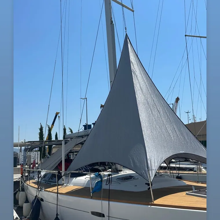 Grey shade sail peaked over the deck of a yacht at her berth