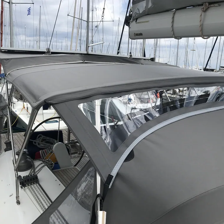 Grey cockpit enclosure with clear panels closing in the aft deck of a sailing yacht