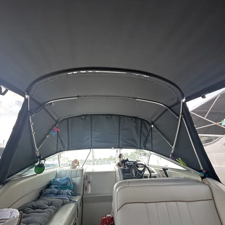 Grey enclosure and bimini over the cockpit of a motor yacht at her mooring