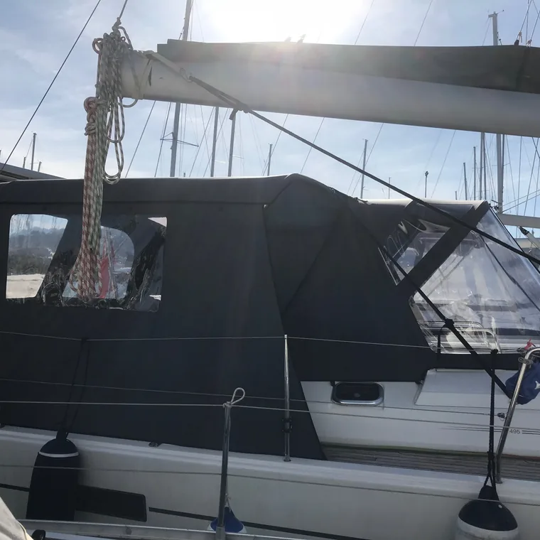 Dark cockpit enclosure running the length of a yacht's cockpit