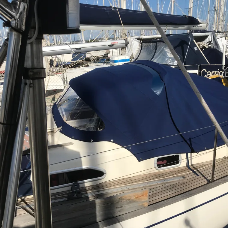 Navy cockpit enclosure closed over the cockpit in a marina