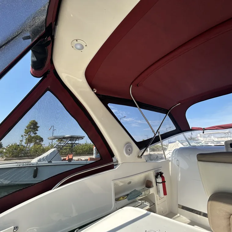 Inside a red-trimmed cockpit enclosure, looking out over the water