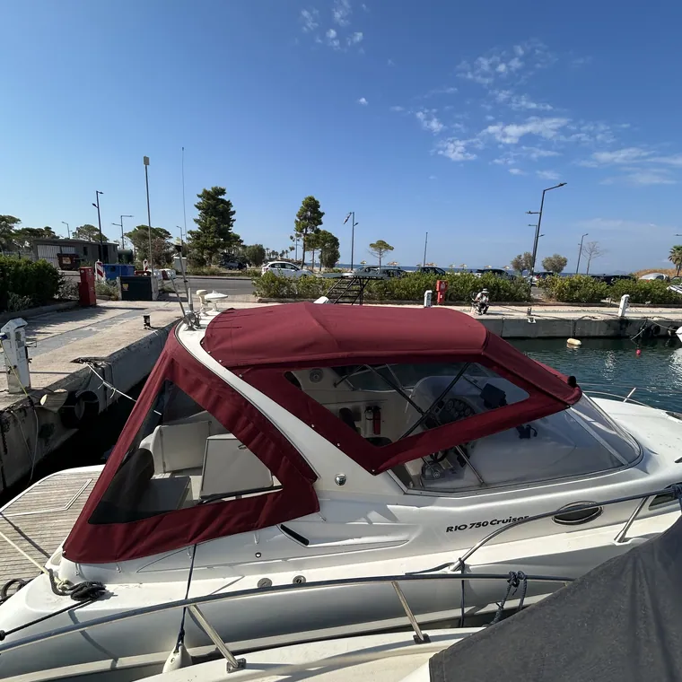 Red-trimmed enclosure over the cockpit of a motor yacht at the quay
