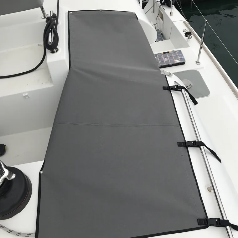 Grey cover across the foredeck of a catamaran