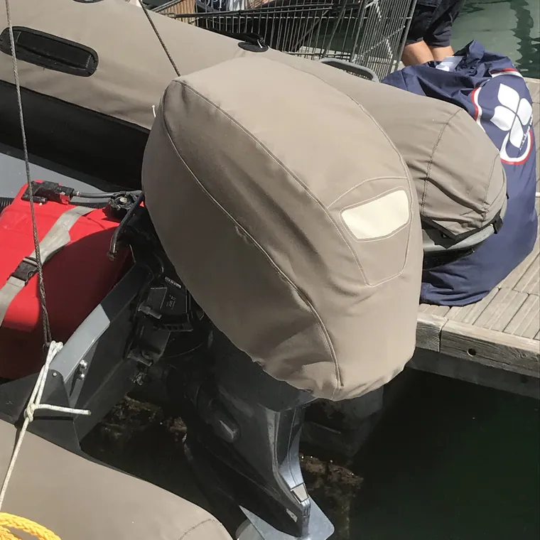 Tan outboard cover on the transom of a tender