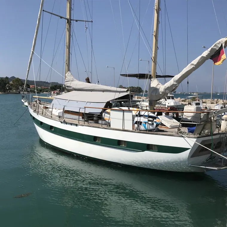 Classic yacht at her mooring with a cream cover over the boom