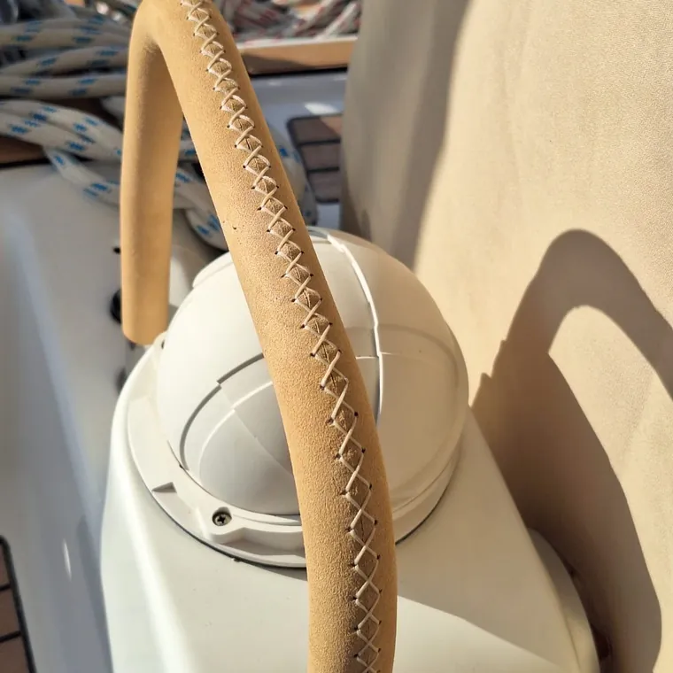 Hand-stitched suede leather sleeve on a curved stainless deck rail