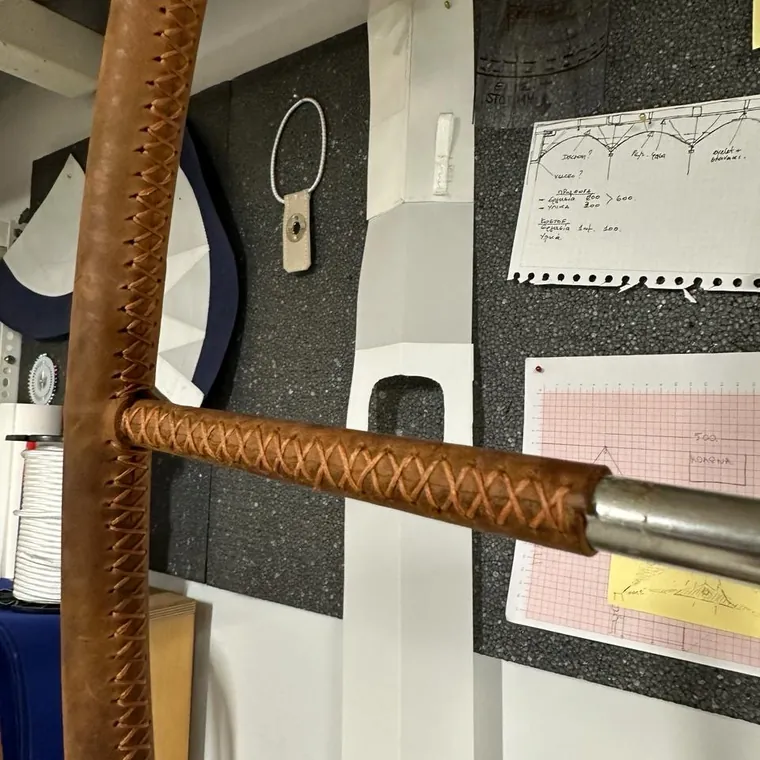 Camel leather laced onto a yacht wheel rim and spoke in the workshop