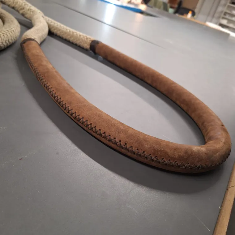 Brown leather stitched along a mooring line on the workshop bench