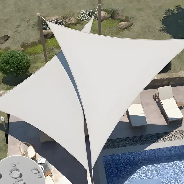White shade sail tensioned over a terrace and sun loungers