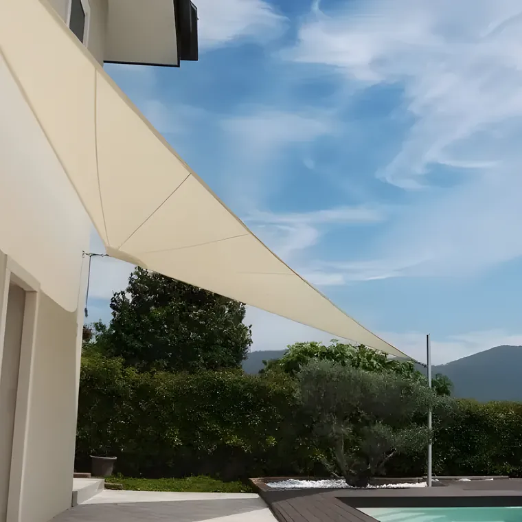 Cream sail shading a terrace, hills beyond