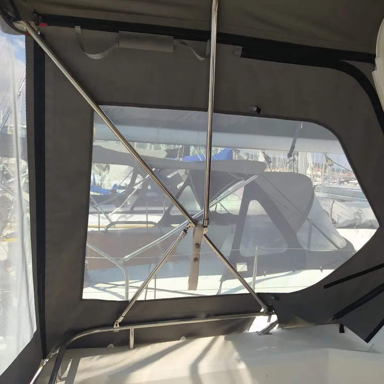 Clear side panel zipped in beside the companionway, the marina beyond