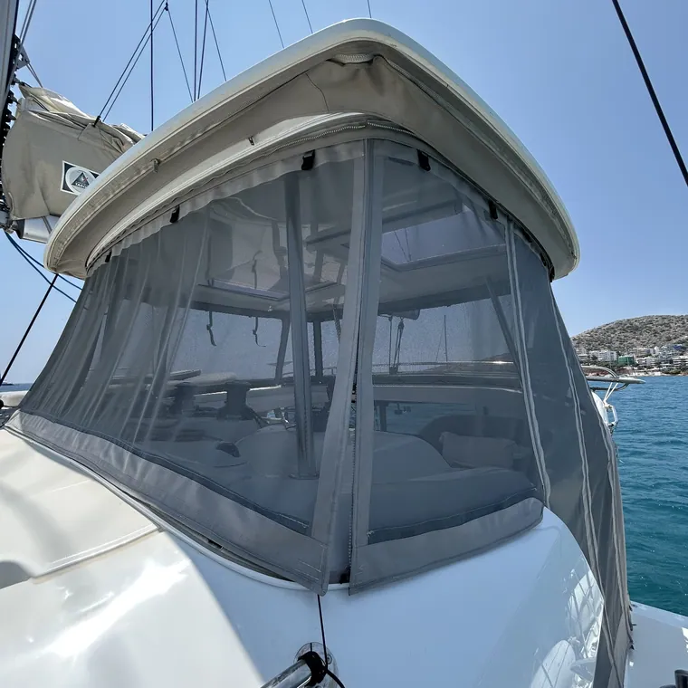 Clear panels wrapped around the cockpit of a yacht in a marina