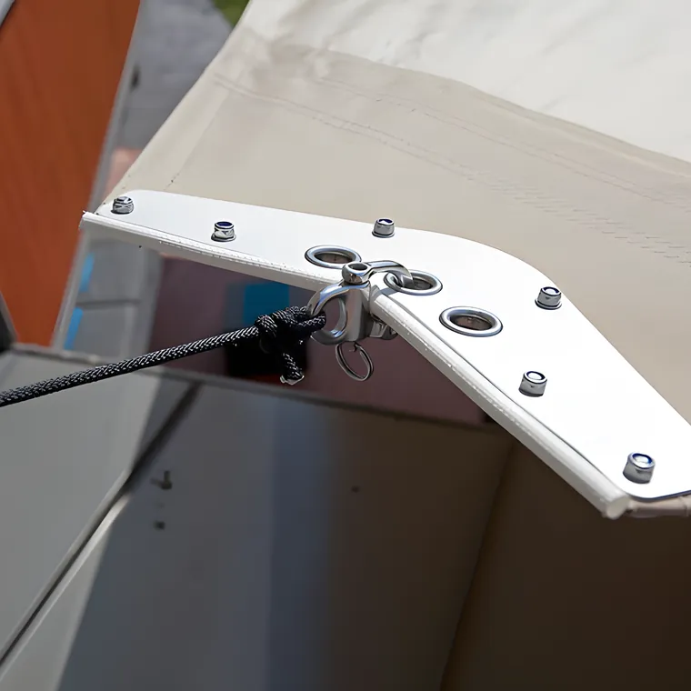An aluminium corner plate bolted through a sail, with the tensioning wire attached