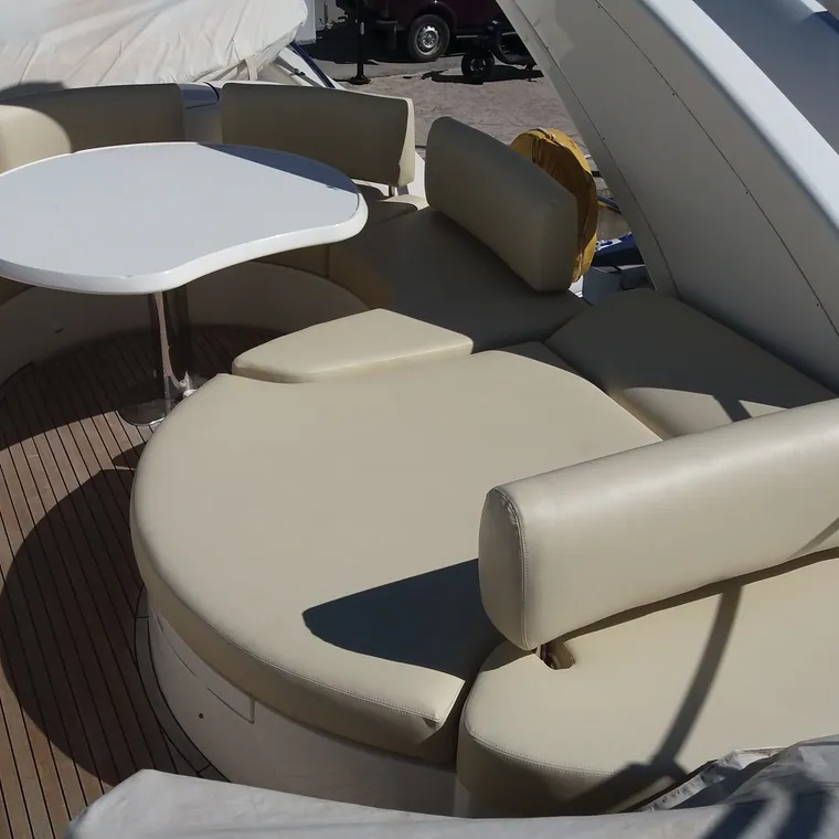 Cream cockpit settee wrapped around a table on a teak deck