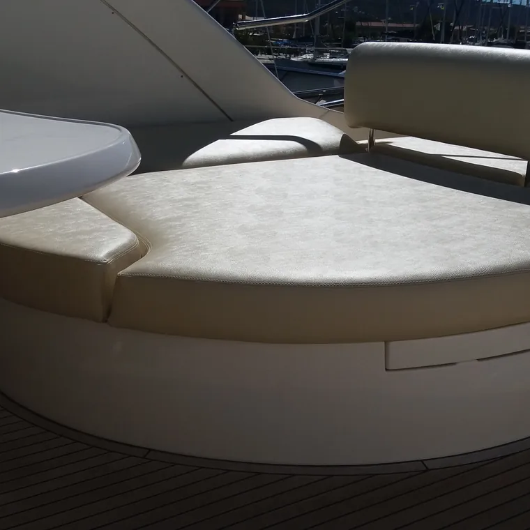 Curved cream settee in the saloon of a motor yacht