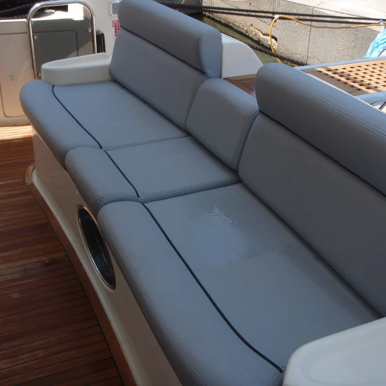 Grey cockpit settee against a teak deck