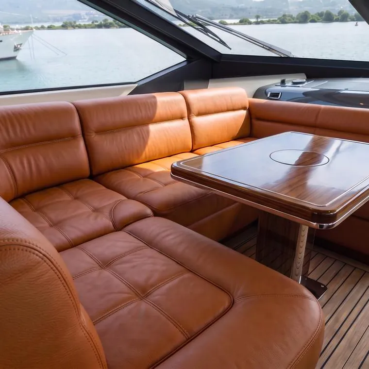 Tan leather cockpit settee wrapped around a table on a motor yacht