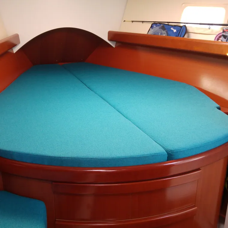 Turquoise cushions on a curved settee in a varnished timber interior