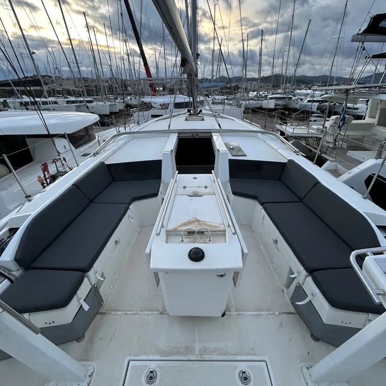 Charcoal cushions and backrests along both cockpit benches of a sailing yacht at dusk