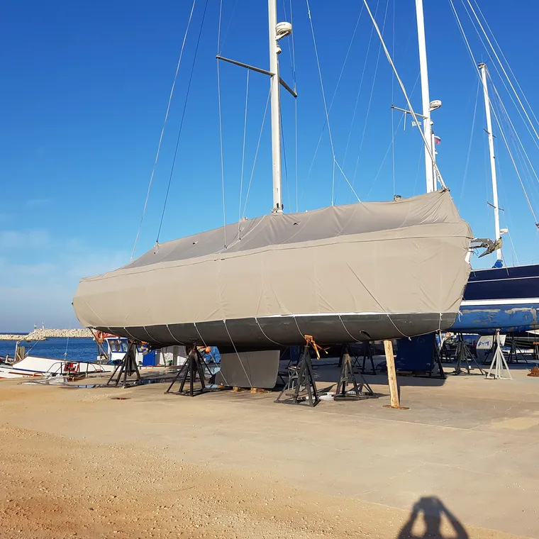 Yacht laid up on the sand under a full winter cover