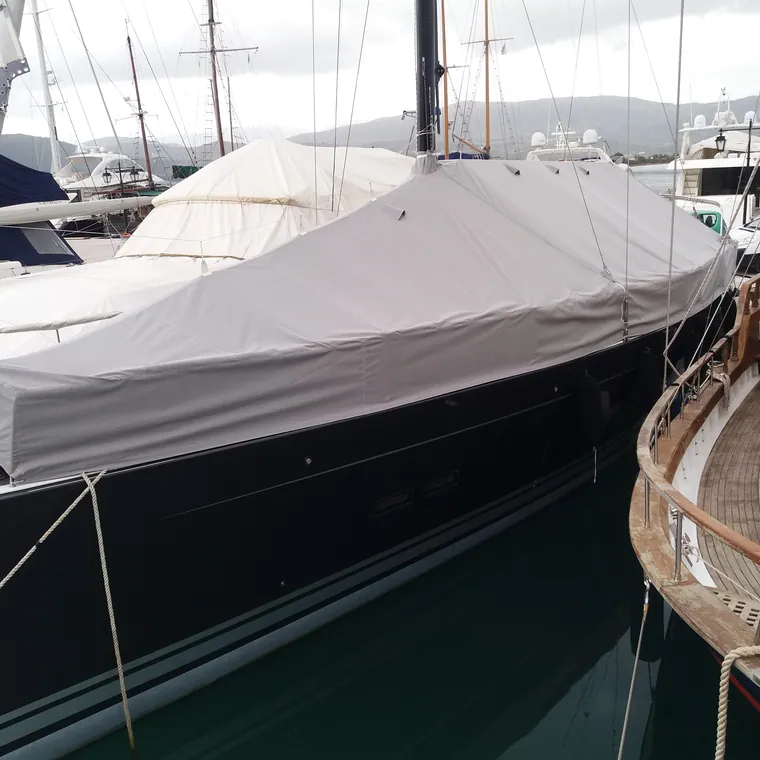 Motor yacht at the quay under a fitted winter cover