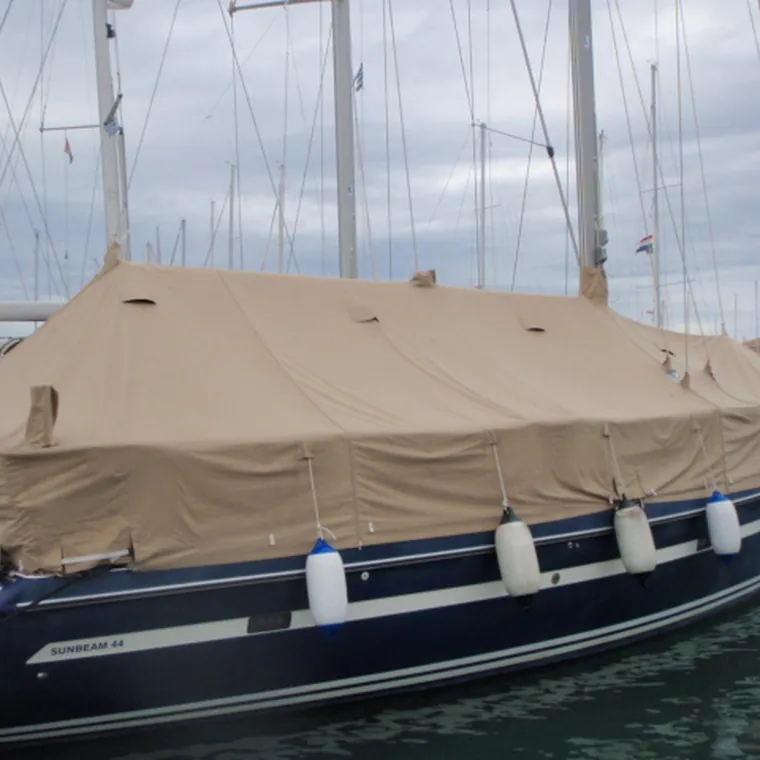 Traditional wooden boat under a tan cover on the water