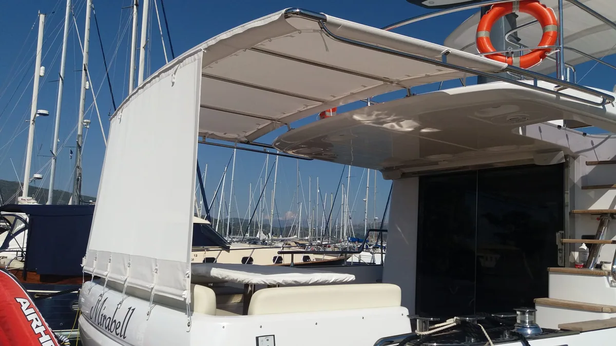 White bimini shading the cockpit and boarding steps of a catamaran