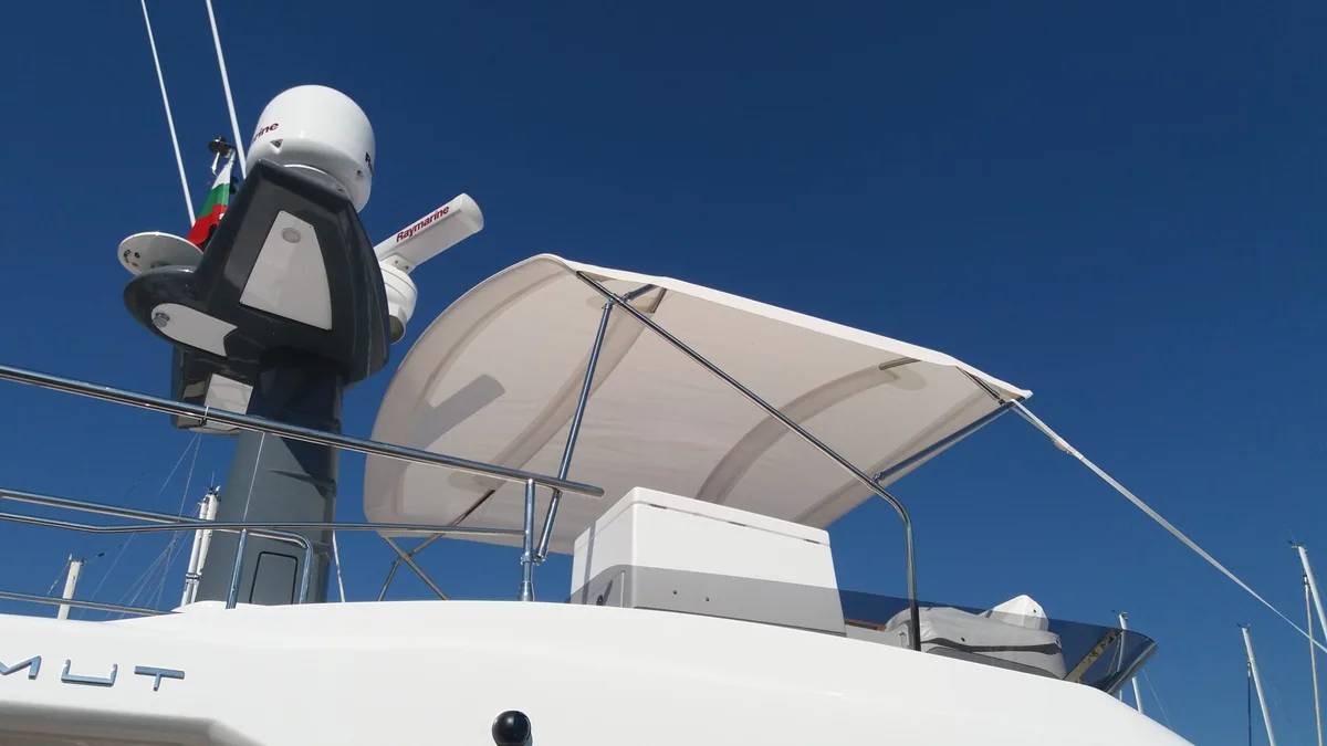 White bimini over the helm of a motorboat's flybridge