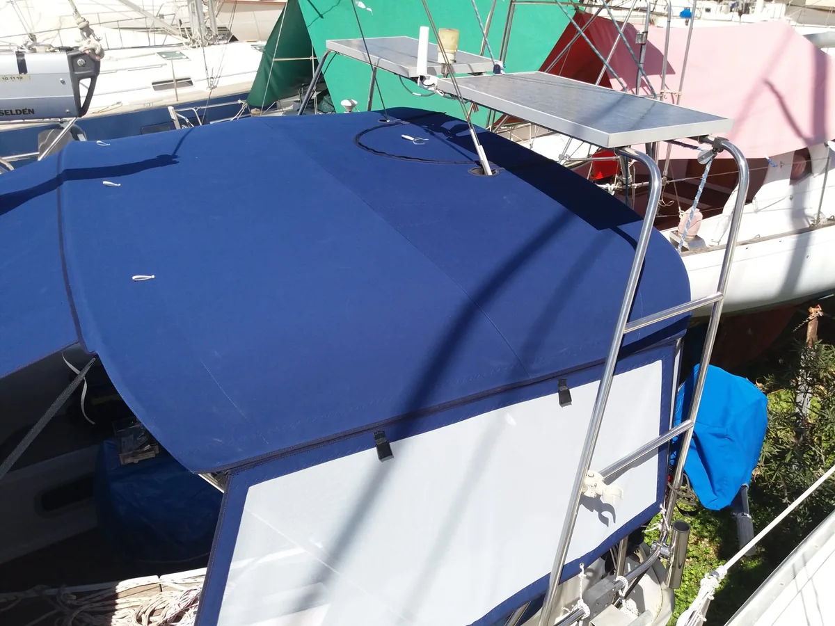 Blue bimini stretched over the cockpit of a motorboat at its berth